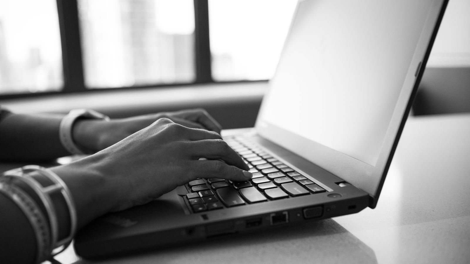 Communicatieadviseur werkt met een AI-assistent op een laptop