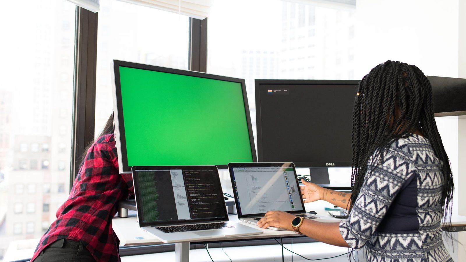 Colleagues reviewing dashboards on several screens